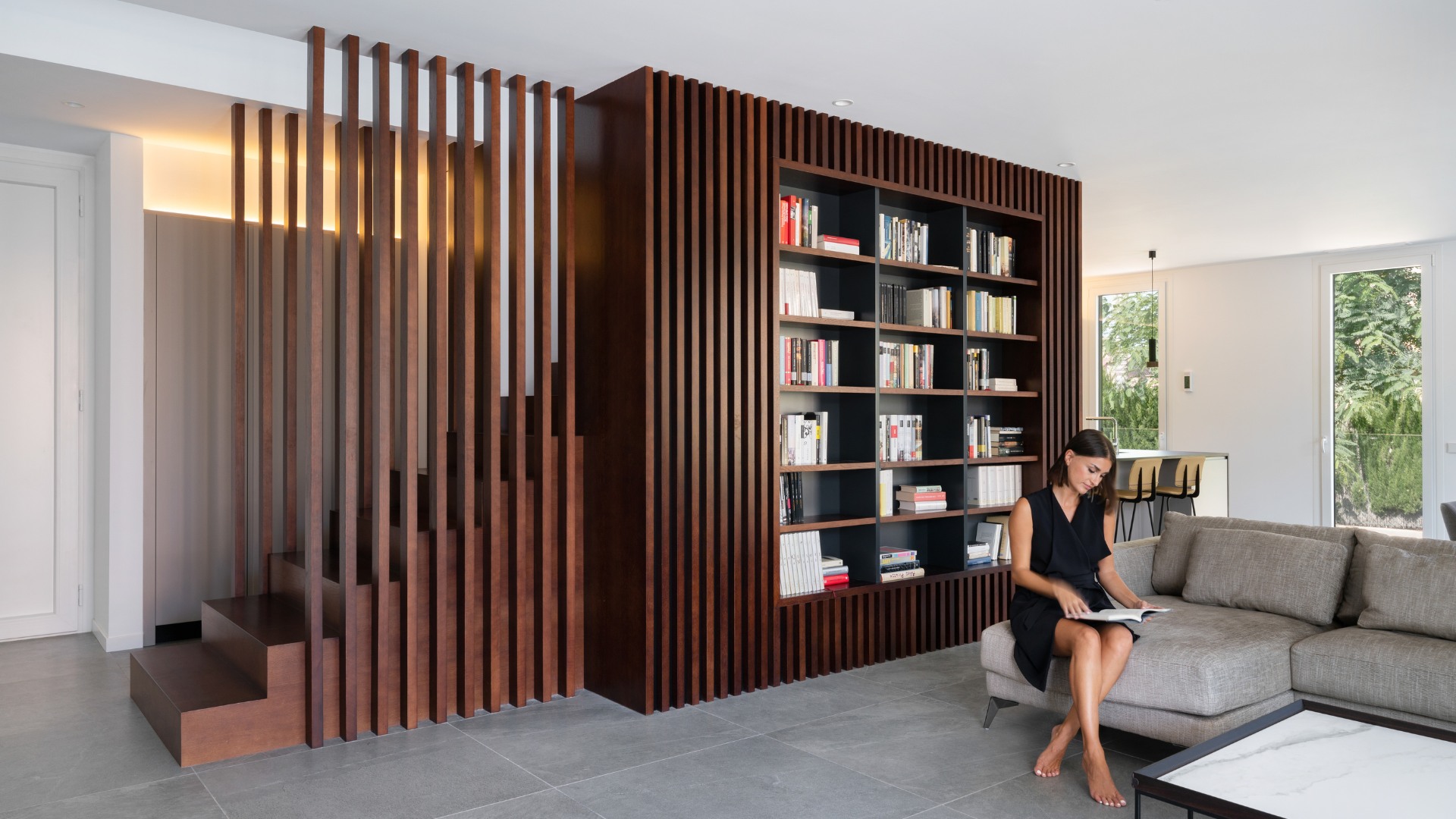 Bibliothèque en bois séparatrice salon cuisine dans une maison modulaire de luxe