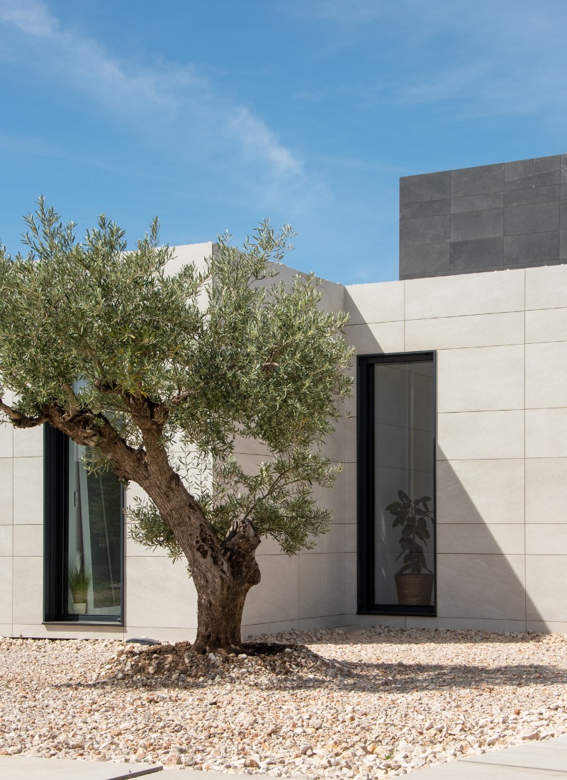 Urbanisation et porche dans maison préfabriquée Madrid facade avec revêtement céramique noir et gris