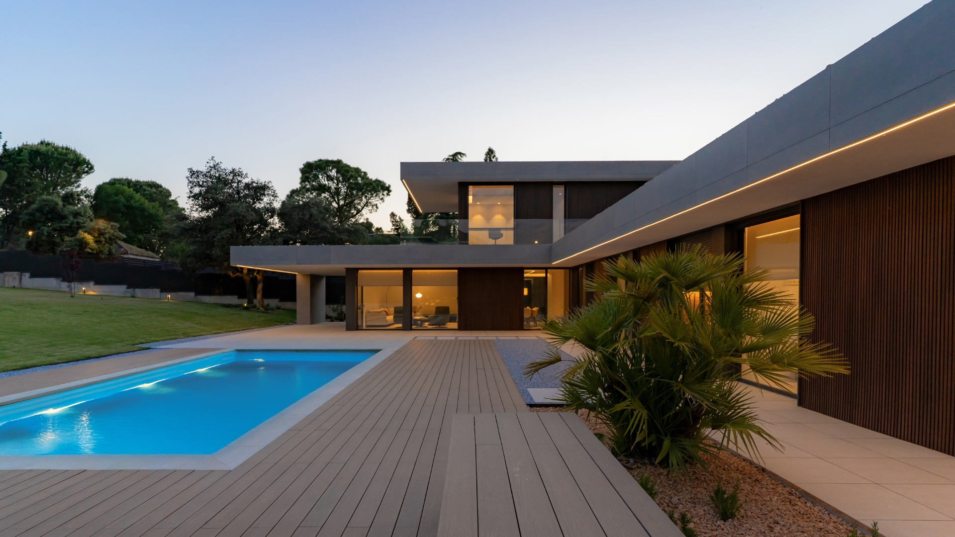 Porche et piscine dans une maison en forme de L éclairée par des lumières LED