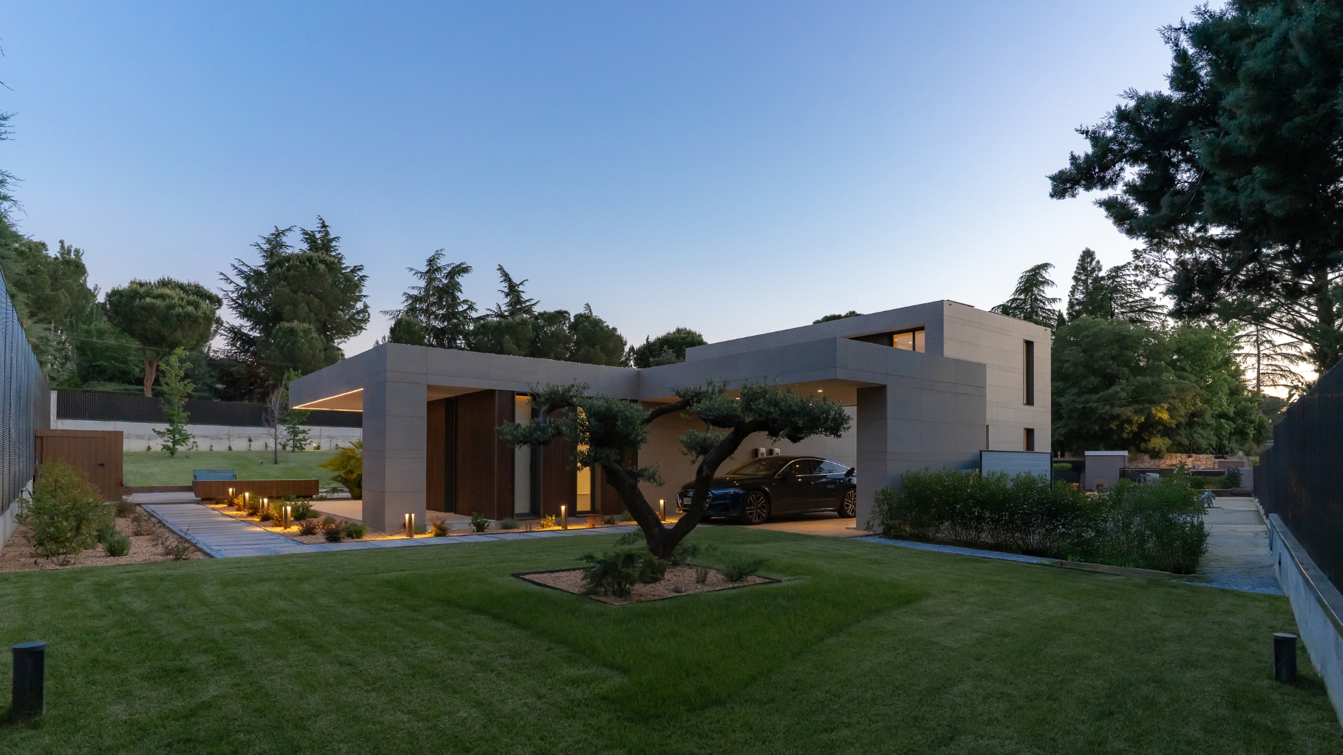 Maison modulaire de luxe en forme de L avec garage éclairé par une lumière LED