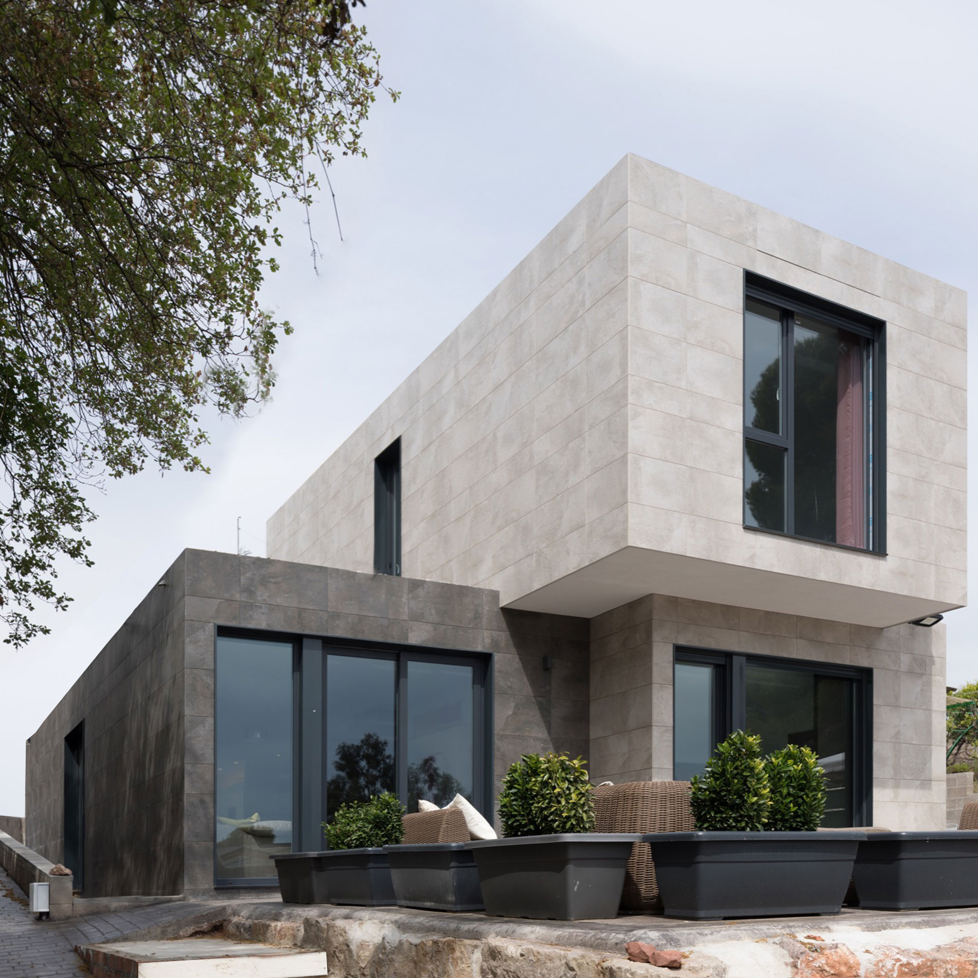 Façade originale maison modulaire composée de carreaux de porcelaine gris et noirs