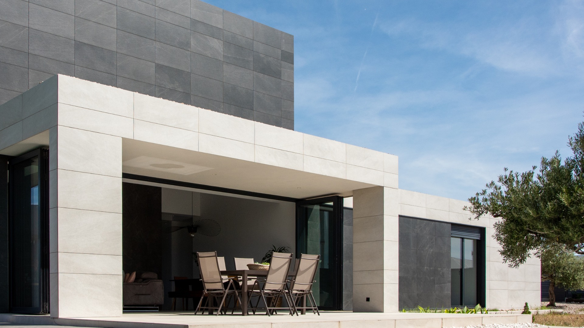 Porche dans maison préfabriquée Madrid facade avec revêtement céramique noir et gris