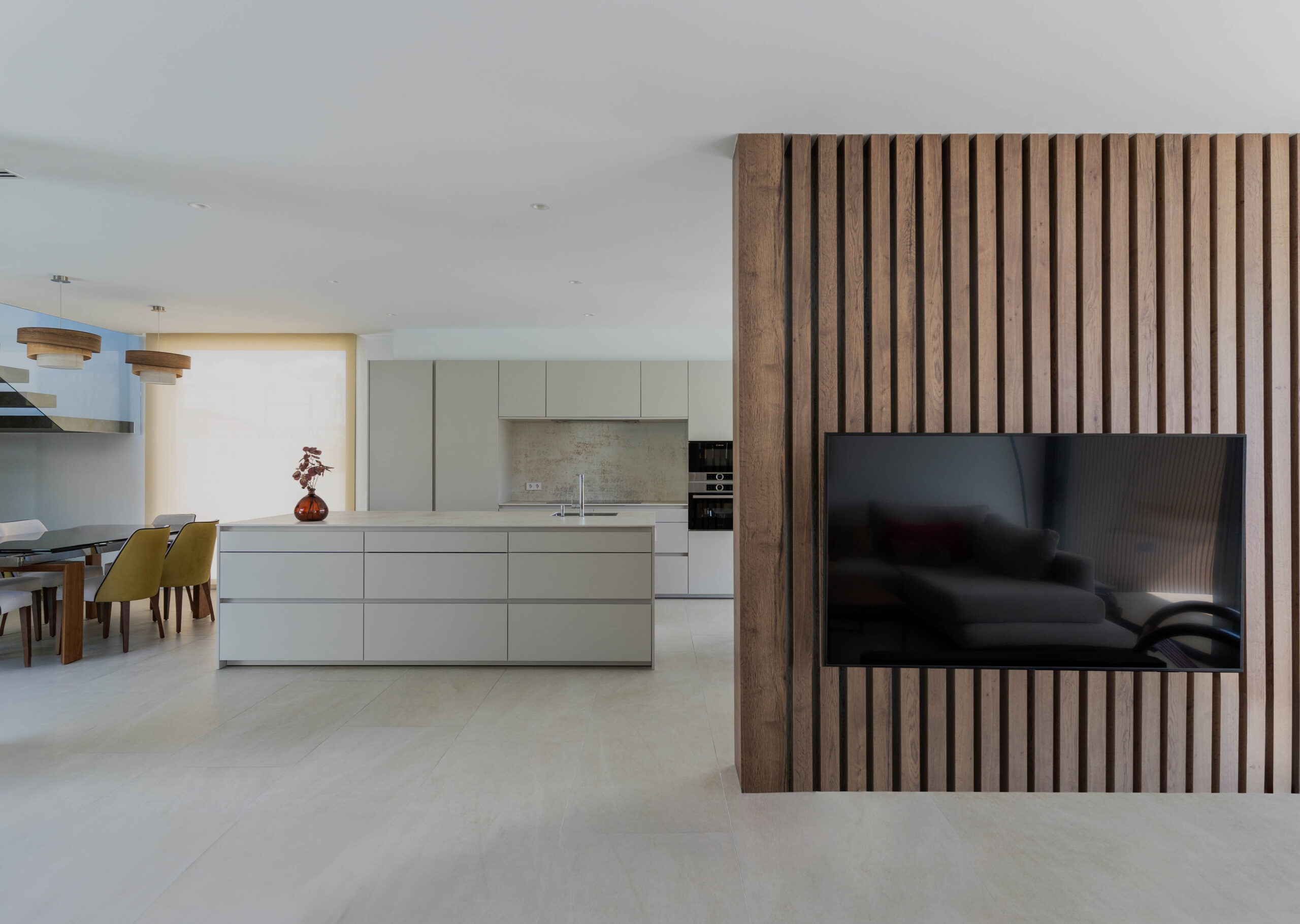 Salon dans une maison modulaire de luxe avec un mur recouvert de bois séparant les pièces
