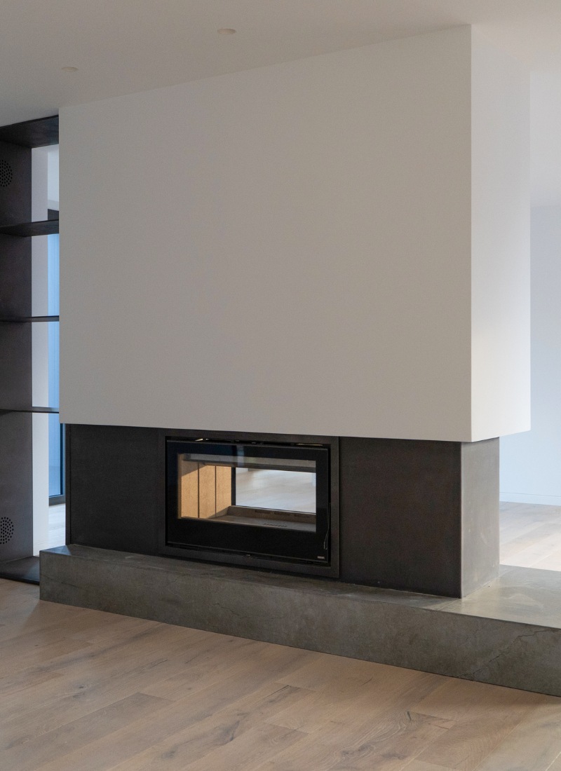 Cheminée à l'intérieur d'une maison modulaire séparant les pièces