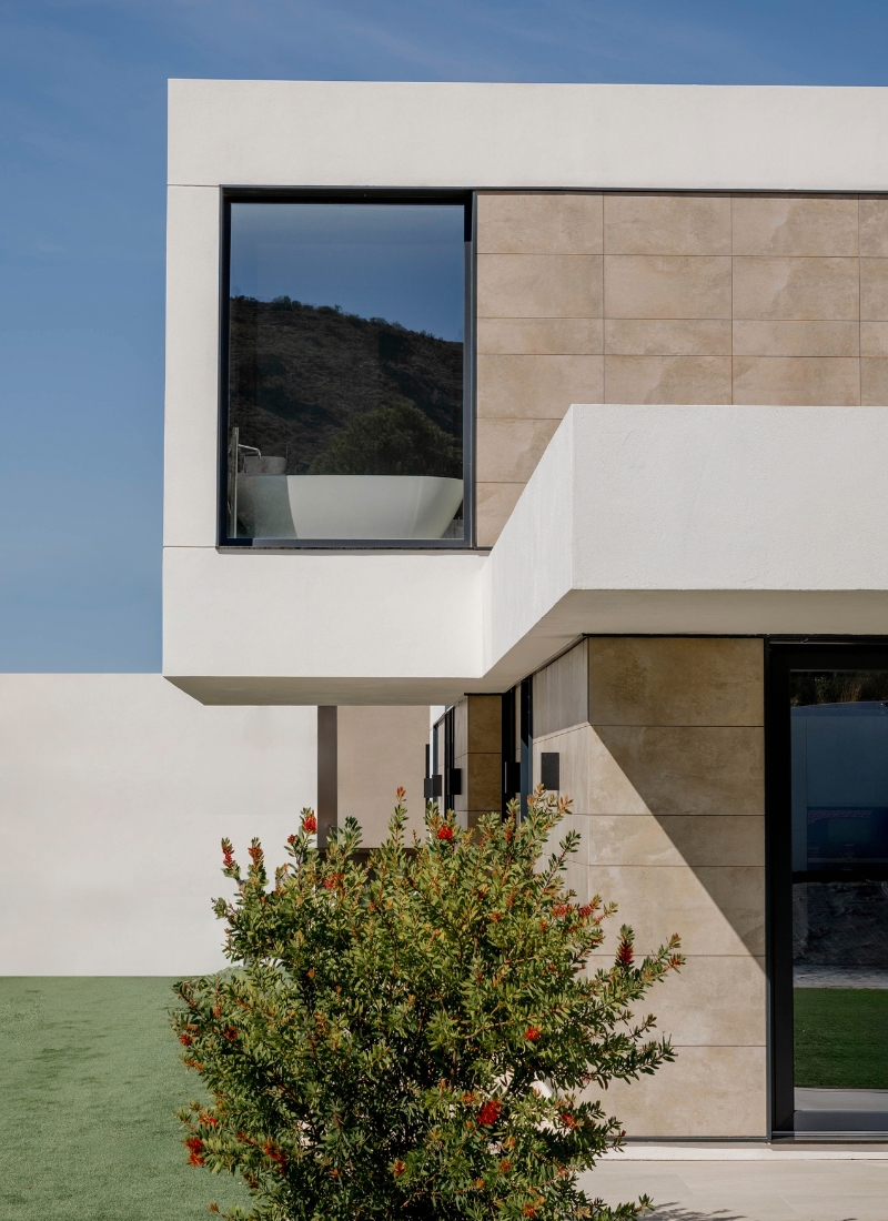 Logement modulaire avec porte-à-faux et façade en grès cérame avec de grandes baies vitrées