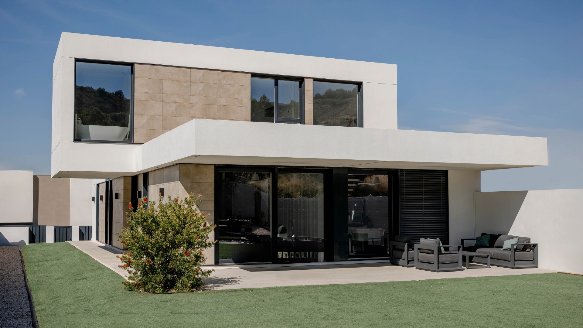 Maison modulaire avec façade en grès cérame, porche et avant-toit surplombant le jardin
