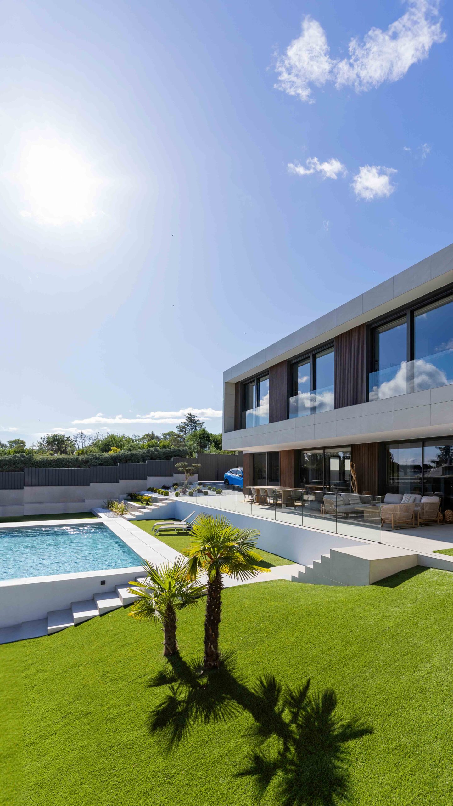 Maison modulaire de luxe sur mesure avec façade en bois technologique, porte-à-faux et piscine sur la pente