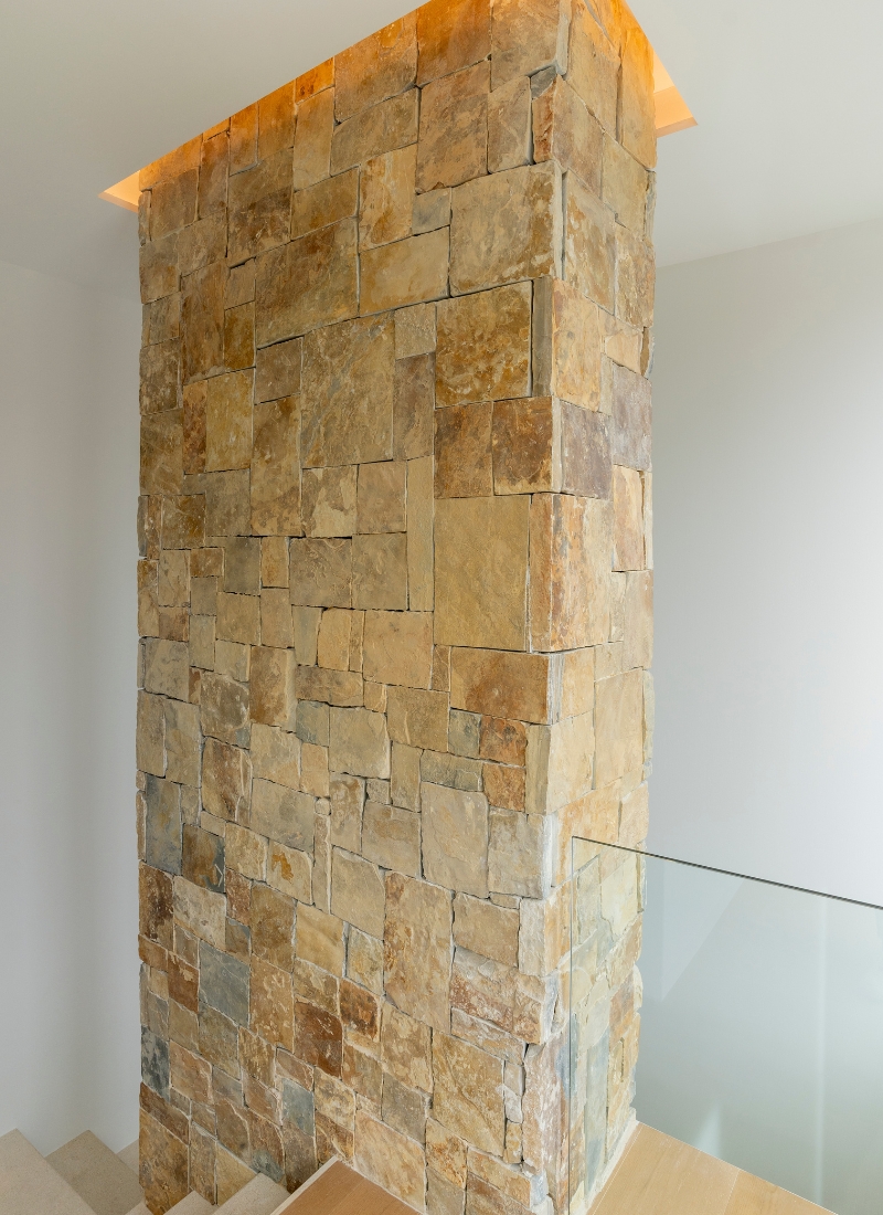 Maison préfabriquée avec aménagement intérieur en mur de pierre naturelle et fosseaux