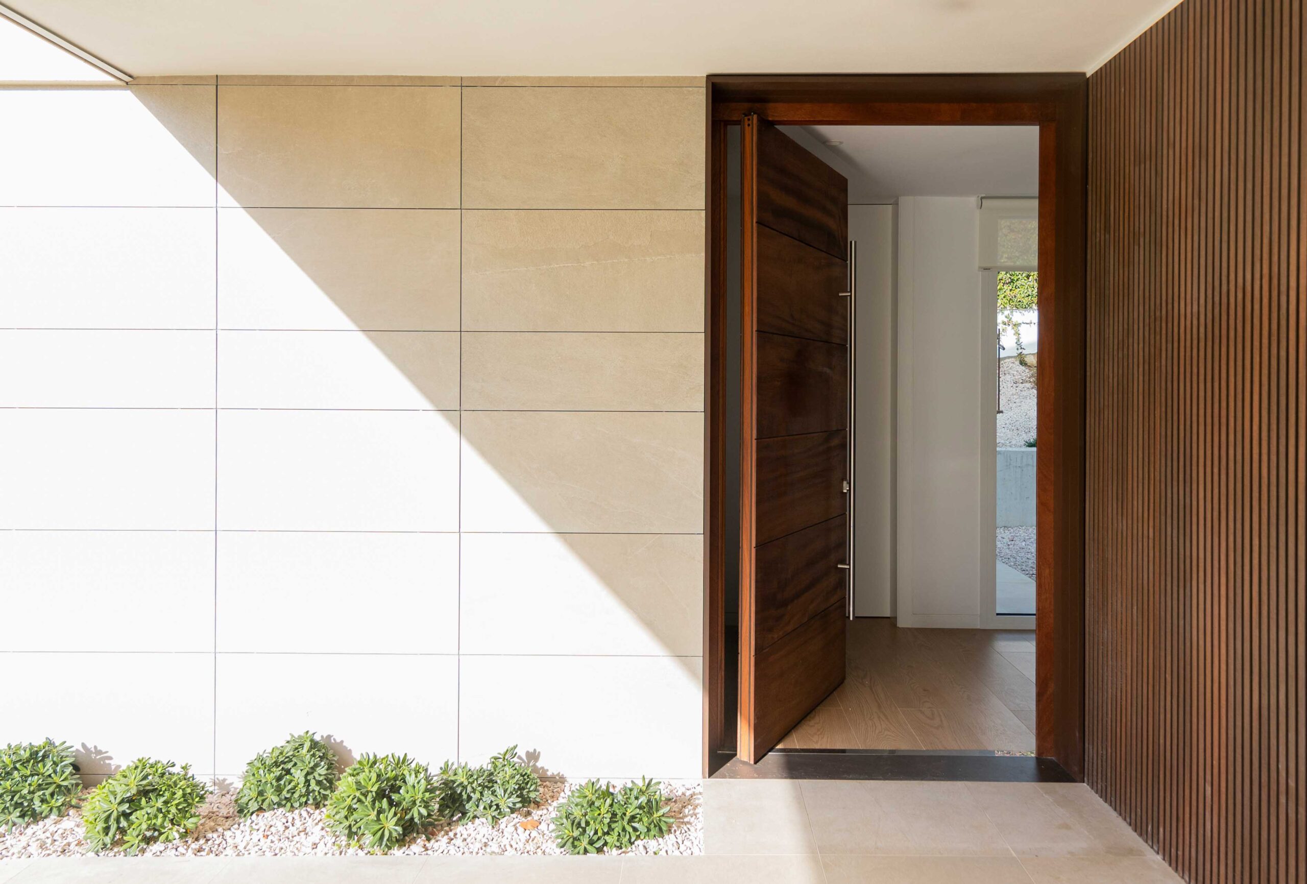 Porte pivotante à l'entrée de la maison préfabriquée de luxe