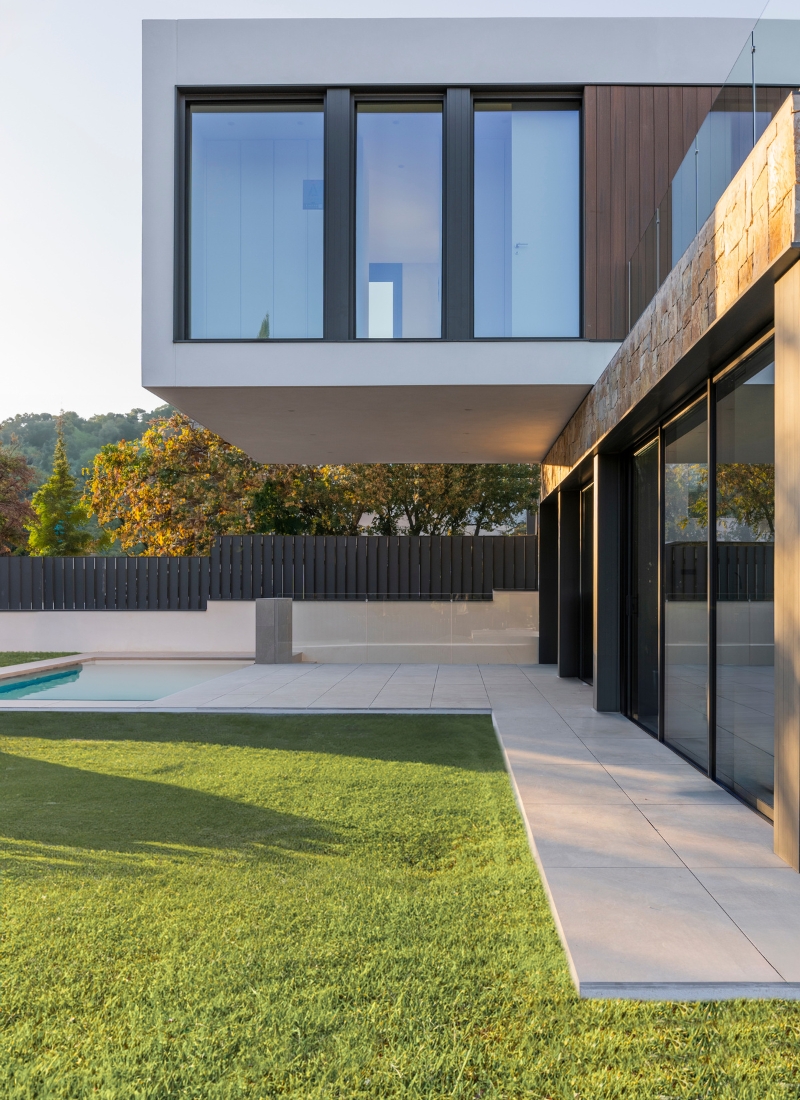 Maison préfabriquée de style méditerranéen à Barcelone avec façade en porte-à-faux et porche avec grandes baies vitrées