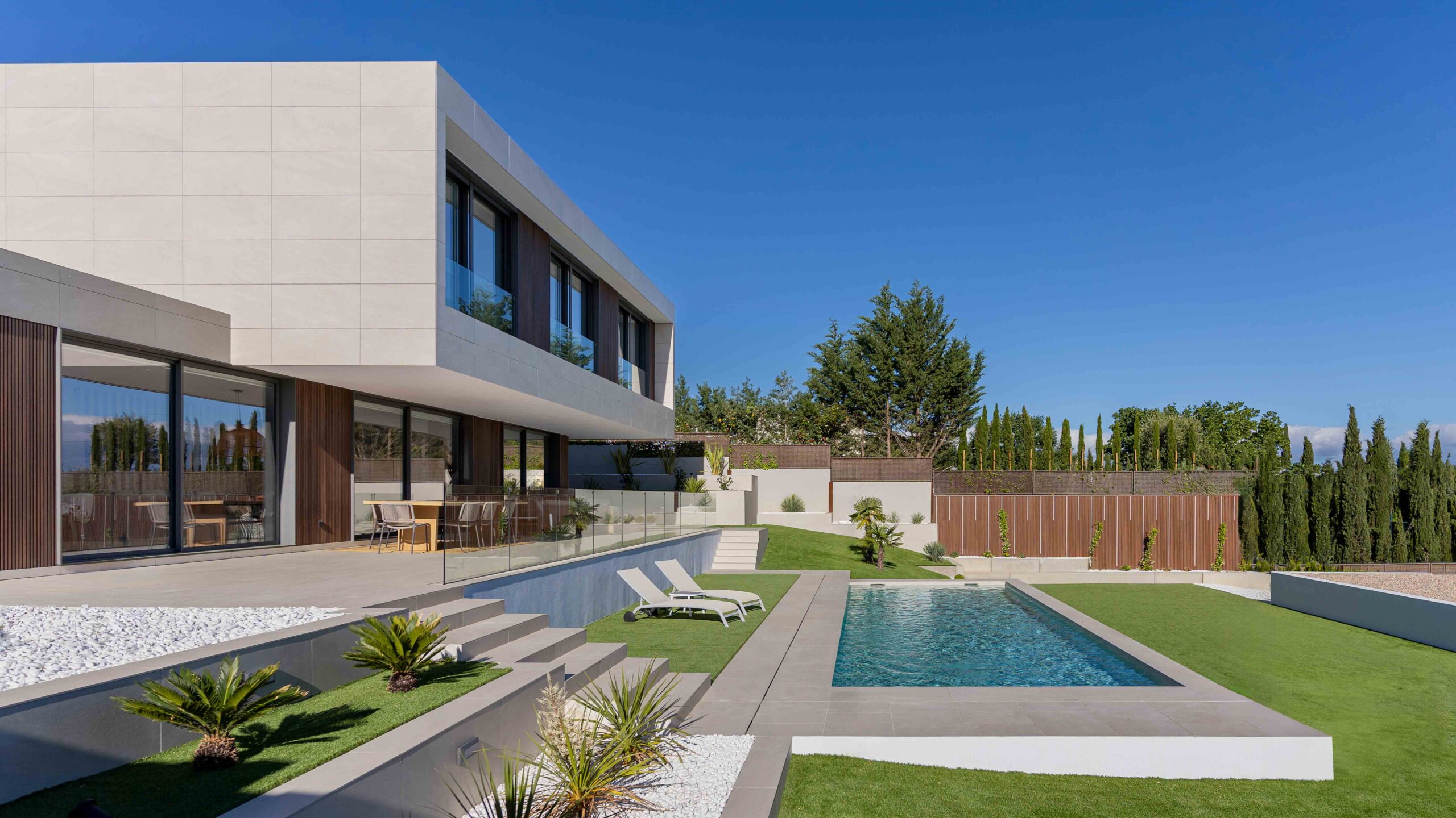 Vue sur la piscine avec façade en porte-à-faux de la maison modulaire de luxe sur mesure en Espagne inhaus