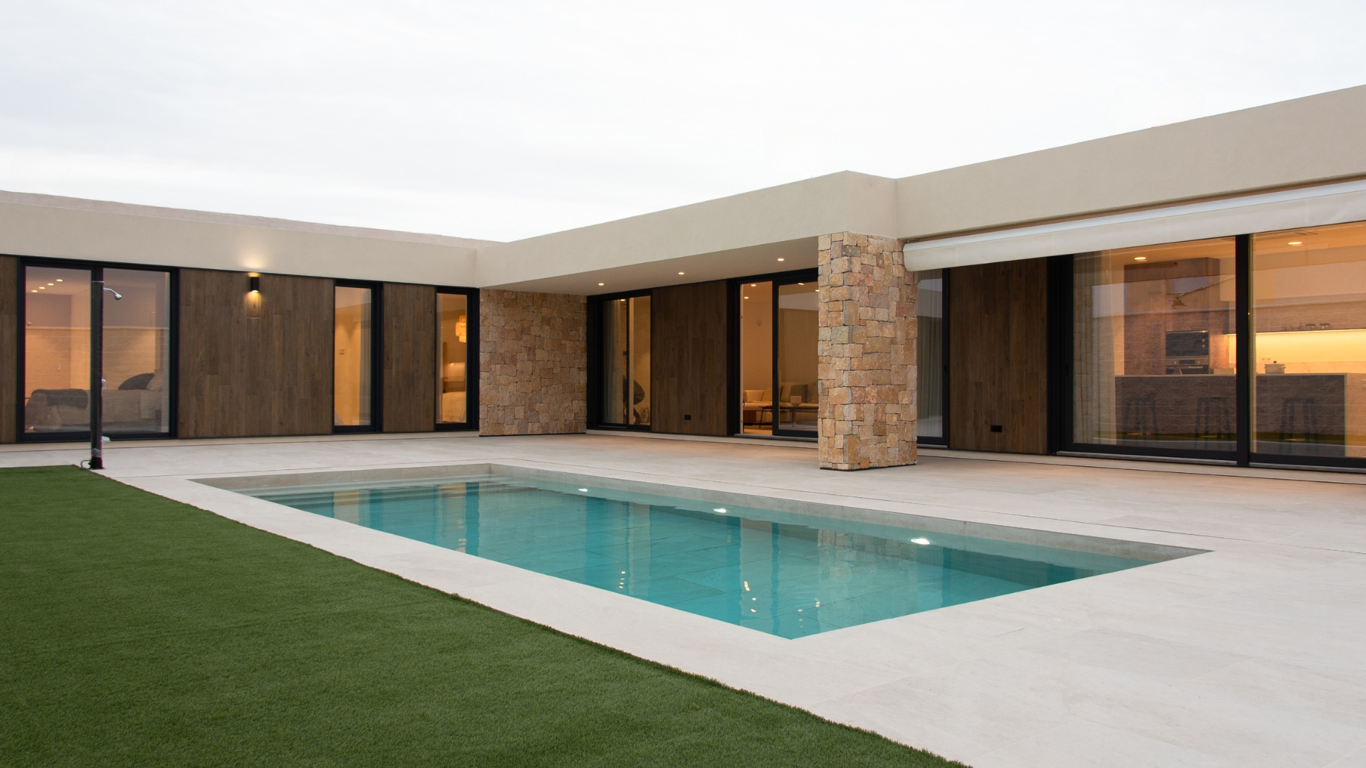 Extérieur de la maison préfabriquée avec baies vitrées donnant sur la piscine