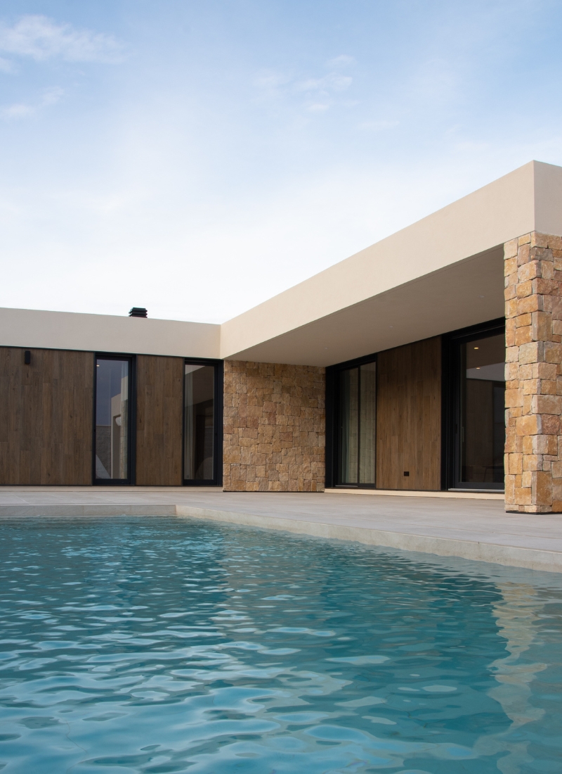 Maison préfabriquée avec piscine et matériaux tels que la pierre naturelle et le bois