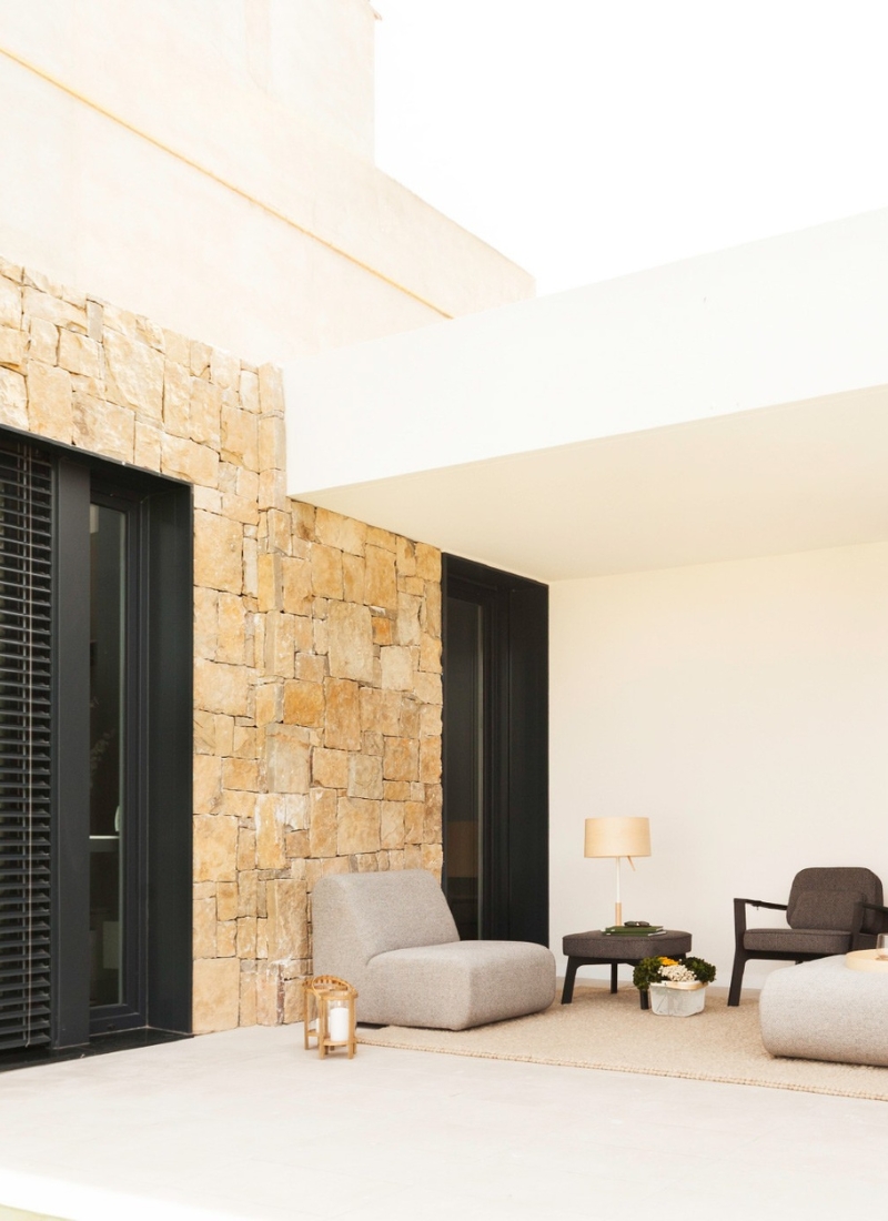 Façade en pierre naturelle et blanche de la zone extérieure avec terrasse